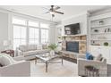 Bright living room featuring a stone fireplace, built-in shelves, and plenty of natural light at 1209 Cedar Park Dr, Pineville, NC 28134