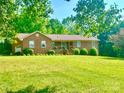 Charming brick home featuring a covered porch and a well-manicured lawn at 16480 Indian Mound Rd, Norwood, NC 28128