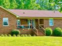 Classic brick home with a cozy front porch and manicured shrubs at 16480 Indian Mound Rd, Norwood, NC 28128