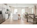 Open concept kitchen and dining area with white cabinets and hardwood floors at 1805 Woodlands Pointe Dr, Charlotte, NC 28216