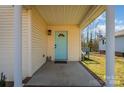 Covered porch with a light teal door and brick flooring at 222 E Alabama Ave, Bessemer City, NC 28016