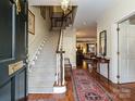 Bright and spacious entryway with hardwood floors, staircase, and views to living room at 232 Perrin Pl, Charlotte, NC 28207