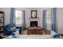 Cozy living room featuring a fireplace, plush seating, and large windows offering ample natural light at 126 Rustling Waters Dr, Mooresville, NC 28117