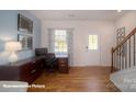 Bright office space with hardwood floors, large desk, and natural light, ideal for remote work at 126 Rustling Waters Dr, Mooresville, NC 28117