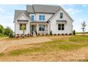 Beautiful two-story home featuring a quaint front porch and professionally landscaped yard at 320 Triple Ponds Ct, Clover, SC 29710
