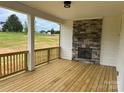 Inviting covered patio with a stone fireplace and wood flooring, perfect for outdoor relaxation and entertainment at 320 Triple Ponds Ct, Clover, SC 29710