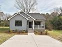Charming gray home featuring a well-manicured lawn, black trim windows, and concrete driveway at 409 Mint St, Rock Hill, SC 29730