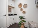 A modern laundry room with white cabinets, granite countertop, decorative wall baskets, and plant at 3013 Old Glory Dr # 24, Gastonia, NC 28056