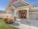 Inviting front porch with double doors and stone pillars at 500 Planters Way, Mount Holly, NC 28120