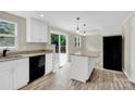 Bright kitchen features an island, stainless steel appliances, granite countertops, and deck access at 9106 Nash Ave, Charlotte, NC 28213