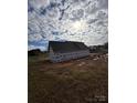 Side view of new home construction, partially covered, in a rural landscape at 184 Maplewood Ln, Taylorsville, NC 28681