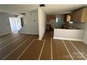 An unfinished living room with bare walls, a large window, and a view into the adjacent kitchen area at 184 Maplewood Ln, Taylorsville, NC 28681
