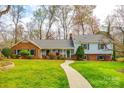 Charming split-level home featuring a well-manicured lawn, inviting walkway, and a mix of brick and siding at 3319 Mill Pond Rd, Charlotte, NC 28226