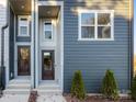 New construction exterior showing 2 townhome front doors, with a dark metal fence and small evergreen bushes at 8005 Elevate Ct, Charlotte, NC 28205