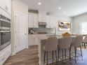 Modern kitchen with stainless steel appliances, island seating, and white cabinetry at 1531 Harper Landing Blvd, Stanley, NC 28164