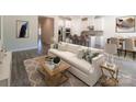 Sunlit living room features modern furnishings and open-concept design to kitchen and dining area at 1531 Harper Landing Blvd, Stanley, NC 28164
