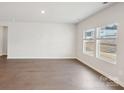 Spacious living room with hardwood style flooring and two large windows that provide plenty of natural light at 1531 Harper Landing Blvd, Stanley, NC 28164