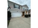 Two-story house with a beige exterior, white garage door, and basketball hoop at 3960 Farmington Ridge Pkwy, Charlotte, NC 28213