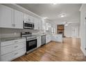 Modern kitchen featuring white cabinets, granite countertops, and stainless steel appliances at 4759 Mel Nunnery Rd, Fort Lawn, SC 29714