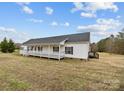 Ranch-style house with a wide porch and neutral siding, sitting on a well-manicured lawn under a blue sky at 4759 Mel Nunnery Rd, Fort Lawn, SC 29714