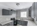 Modern kitchen with gray cabinets, granite counters, and black appliances at 612 Calvary St, Shelby, NC 28150