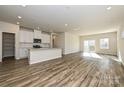 Open-concept living area with modern kitchen, stainless appliances, island, and wood-look floors at 827 Blue Canyon Dr, York, SC 29745