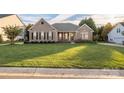 Ranch style home with a well-manicured lawn and mature trees at 1108 Butterburr Dr, Matthews, NC 28104