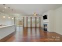 Bright living room featuring hardwood floors, fireplace, and sliding glass doors to the yard at 14509 Batteliere Dr, Charlotte, NC 28278