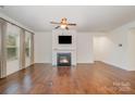 Spacious living room boasting hardwood floors, fireplace, ample natural light, and modern ceiling fan at 14509 Batteliere Dr, Charlotte, NC 28278