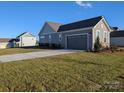 Two-car garage with a paved driveway and landscaping at 1858 Yardley St, Rock Hill, SC 29732