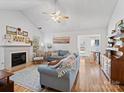 Bright living room with hardwood floors, fireplace, and comfy seating at 2532 Governors Pointe Ne Ct, Concord, NC 28025