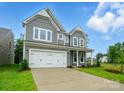 Beautiful two-story home featuring gray siding, a two-car garage, and a lush green lawn at 5404 Verona Rd # 36, Charlotte, NC 28213