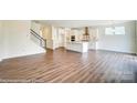Open-concept living room with wood floors, white trim, and an adjoining kitchen with island at 5404 Verona Rd # 36, Charlotte, NC 28213