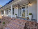 Inviting brick porch with decorative plants and lantern-style lighting at 5529 Five Knolls Dr, Charlotte, NC 28226