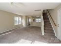 Living room featuring stairs, carpet, and neutral walls at 13406 Tartarian Ct, Charlotte, NC 28215