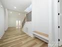 Bright and airy foyer with light wood-look floors, built-in bench, and staircase with metal railing at 2005 Plain Field Dr, Bessemer City, NC 28016