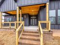 Charming front porch features a wooden ceiling, black metal railings, and brick steps leading to the entrance at 2005 Plain Field Dr, Bessemer City, NC 28016