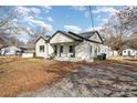 Wide view of white home with mature trees and landscaping on a clear day at 5204 Dellinger Cir, Cherryville, NC 28021