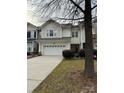 Two-story townhome with attached garage and tree in foreground at 6132 Pale Moss Ln, Charlotte, NC 28269