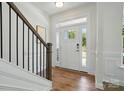 Bright foyer with hardwood floors, staircase with dark metal railings, and natural light at 8230 Verona Rd # 80, Charlotte, NC 28213