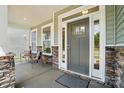Cozy covered front porch with stone pillars, seating area, and a stylish front door at 8230 Verona Rd # 80, Charlotte, NC 28213