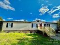 Newly renovated mobile home with a red door and landscaping at 9763 Knightbridge Dr, Concord, NC 28025