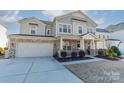 Two-story house with gray siding, stone accents, and a three-car garage at 112 Tetcott St, Mooresville, NC 28115