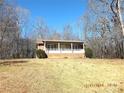 View of a cozy home with a brick foundation and covered porch surrounded by trees in winter at 1857 Williams Cir, Lancaster, SC 29720