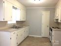 Well-lit kitchen featuring white cabinets, and a stainless steel double-bowl sink at 1857 Williams Cir, Lancaster, SC 29720