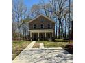 New construction home featuring a brick facade and a long, modern concrete driveway at 4739 Whispering Oaks Dr, Charlotte, NC 28213