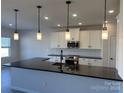 Modern kitchen with stainless steel appliances, white cabinetry and a large island at 6319 Honor Ave, Midland, NC 28107