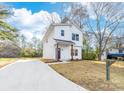 Newly renovated modern home featuring white siding and a smooth concrete driveway at 211 Chestnut St, Shelby, NC 28150