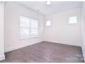 Neutral, empty room with hardwood flooring, white walls and trim, and plenty of natural light at 1364 Cedardale Ln, Denver, NC 28037