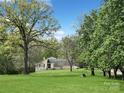 Inviting home surrounded by lush landscaping and mature trees, offering a serene and private setting at 1769 Old Nc 27 Hwy, Mount Holly, NC 28120